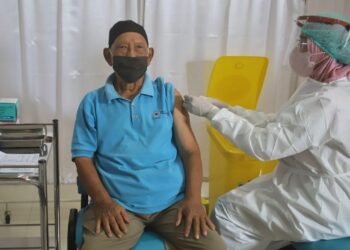 CEGAH PENULARAN: Seorang lansia menerima suntikan vaksin Covid-19 dosis ketiga atau booster.