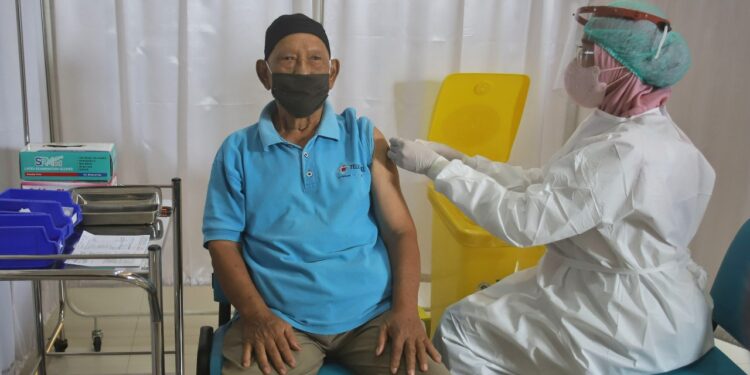 CEGAH PENULARAN: Seorang lansia menerima suntikan vaksin Covid-19 dosis ketiga atau booster.
