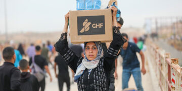KEJAHATAN KEMANUSIAAN: Seorang perempuan Palestina membawa logistik bantuan dari Yayasan Kemanusiaan Gaza (GHF). (FOTO: GETTY IMAGE)