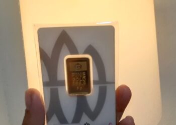 INVESTASI EMAS: Keping logam mulia (LM) Antam 5 gram diperlihatkan oleh model. (FOTO: DOK/KORANINDPOS.COM)