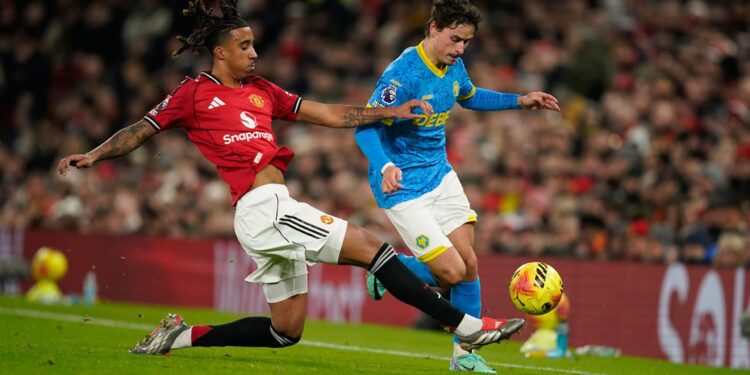 DUEL SENGIT: Pemain Manchester United, Leny Yoro, berebut bola dengan pemain Wolves, Hugo Bueno, pada laga Premier League/Liga Inggris di Manchester, Inggris, Selasa (30/12/2025). (Foto: AP Photo/Dave Thompson)