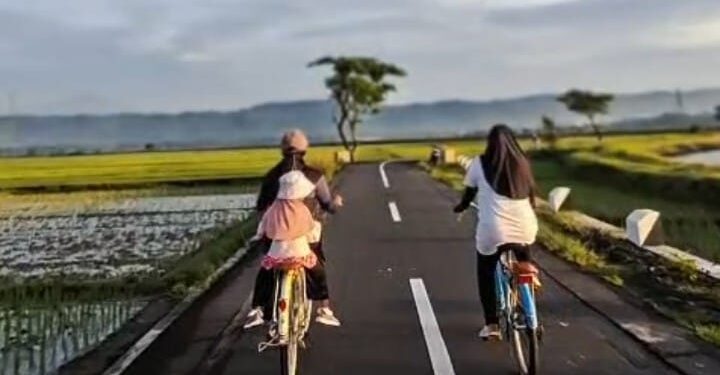 WISATA BANYUMAS: Para pesepeda menikmati suasana pagi menelusuri jalan-jalan desa di tengah hamparan sawah dengan latar Gunung Slamet di Banyumas, Jawa Tengah. (FOTO: Dok/ITF-Banyumas)