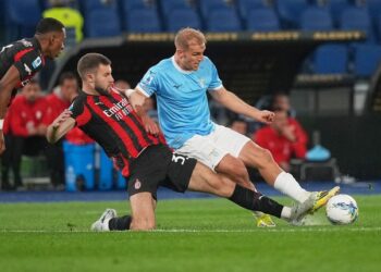 PELUANG EMAS: Bek AC Milan, Strahinja Pavlovic, mencoba merebut bola dari Gustav Isaksen di laga Lazio vs AC Milan. (Foto: (c) AP Photo/Andrew Medichini)