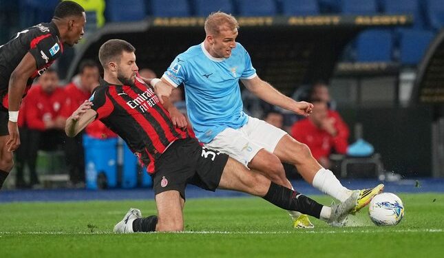 PELUANG EMAS: Bek AC Milan, Strahinja Pavlovic, mencoba merebut bola dari Gustav Isaksen di laga Lazio vs AC Milan. (Foto: (c) AP Photo/Andrew Medichini)