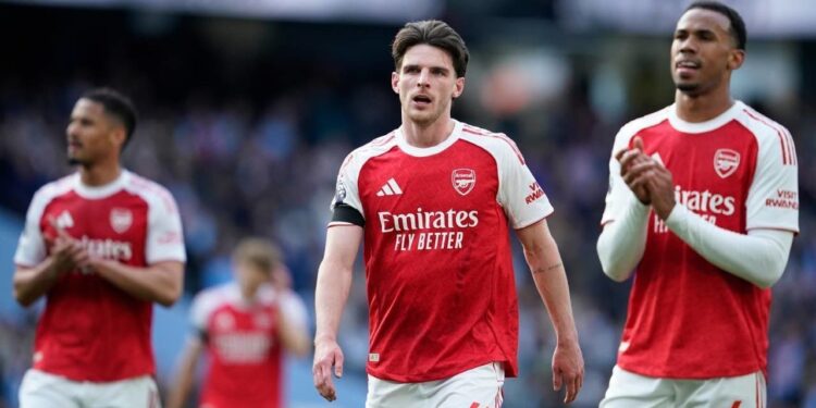 PEKAN BERAT: Pemain Arsenal, Declan Rice, dan rekan setimnya Gabriel Magalhaes di akhir pertandingan Premier League melawan Manchester City pada Minggu (19/4/2026) malam WIB. (Foto: (c) AP Photo/Dave Thompson)