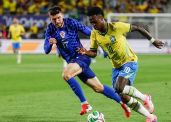 HASIL POSITIF: Vinicius Junior dikawal oleh Petar Sucic dalam laga uji coba internasional antara Brasil vs Kroasia di Camping World Stadium, Florida pada Rabu (1/4/2026). (Foto: (c) AP Photo/Kevin Kolczynski)