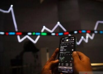 BABAK BELUR: Aktivitas pegawai membuka gadget di dekat monitor pergerakan Indeks Harga Saham Gabungan (IHSG) Bursa Efek Indonesia, Jakarta. (Foto Ilustrasi: Antara Foto/Sigid Kurniawan)