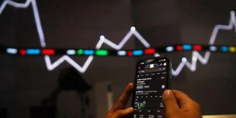 BABAK BELUR: Aktivitas pegawai membuka gadget di dekat monitor pergerakan Indeks Harga Saham Gabungan (IHSG) Bursa Efek Indonesia, Jakarta. (Foto Ilustrasi: Antara Foto/Sigid Kurniawan)