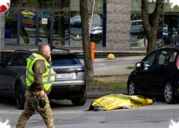 AKSI TEROR: Petugas berjalan di sebelah kantung mayat korban penembakan di Kyiv, Ukraina pada Sabtu (18/4/2026). (Serhii Okunev/AFP/AFP)