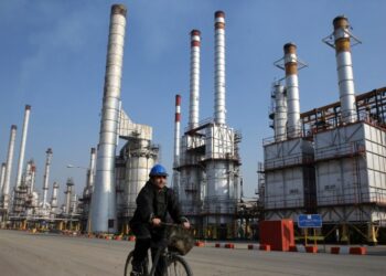 KILANG MINYAK: Pekerja minyak Iran mengendarai sepedanya di kilang minyak selatan Ibu Kota Teheran, Iran. (Foto Ilustrasi: AP)