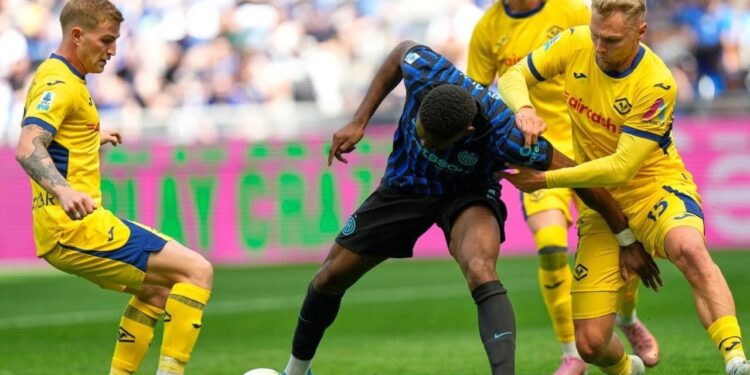 DUEL SENGIT: Pemain Inter Milan, Ange-Yoan Bonny, berebut bola dengan pemain Hellas Verona, Victor Nelsson, dalam pertandingan Serie A pada Minggu (17/5/2026) malam. (Foto: (c) AP Photo/Luca Bruno)