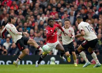 DIKAWAL KETAT: Gelandang Liverpool, Dominik Szoboszlai (kiri), berebut bola dengan pemain Manchester United, Kobbie Mainoo, di Old Trafford pada Minggu (3/5/2026) malam WIB. (Foto: (c) AP Photo/Dave Thompson)