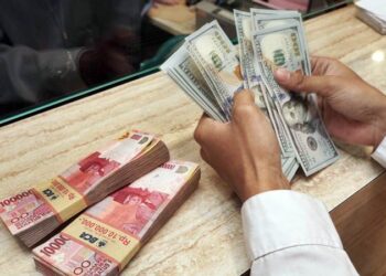 MATA UANG:Nasabah menghitung uang di sebuah Money Changer di Jakarta.(Foto: Dok./Bisnis-Himawan L. Nugraha)