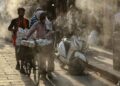 HAWA PANAS: Warga berjalan di bawah alat penyiram air yang dipasang saat musim panas terik di Varanasi, India pada Senin (27/4/2026). (Foto: Niharika Kulikarni/AFP)