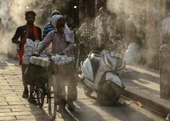 HAWA PANAS: Warga berjalan di bawah alat penyiram air yang dipasang saat musim panas terik di Varanasi, India pada Senin (27/4/2026). (Foto: Niharika Kulikarni/AFP)