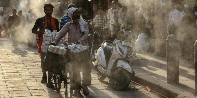 HAWA PANAS: Warga berjalan di bawah alat penyiram air yang dipasang saat musim panas terik di Varanasi, India pada Senin (27/4/2026). (Foto: Niharika Kulikarni/AFP)