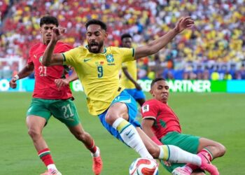 DI LUAR HARAPAN: Pemain Brasil Matheus Cunha (tengah) berduel dengan pemain Maroko Soufiane Rahimi dalam pertandingan Grup C Piala Dunia 2026 pada Minggu (14/6/2026). (Foto: (c) AP Photo/Yuki Iwamura)