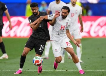 DUEL SENGIT: Pemain Selandia Baru, Sarpreet Singh berebut bola dengan pemain Iran, Saman Ghoddos dalam pertandingan Grup G Piala Dunia 2026, Selasa (16/6/2026). (Foto: (c) AP Photo/Mark J. Terrill)