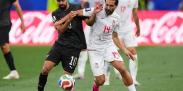 DUEL SENGIT: Pemain Selandia Baru, Sarpreet Singh berebut bola dengan pemain Iran, Saman Ghoddos dalam pertandingan Grup G Piala Dunia 2026, Selasa (16/6/2026). (Foto: (c) AP Photo/Mark J. Terrill)
