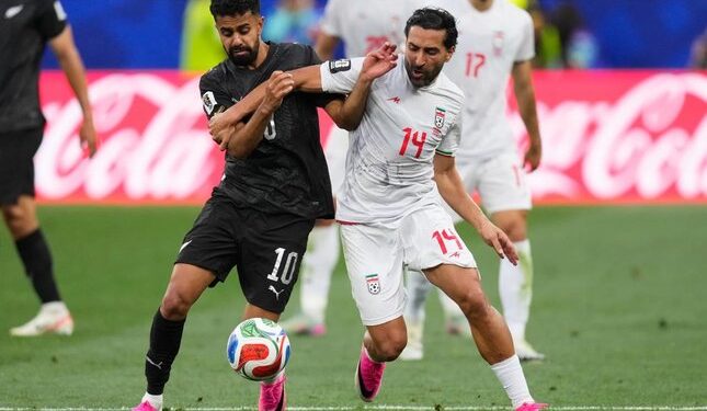 DUEL SENGIT: Pemain Selandia Baru, Sarpreet Singh berebut bola dengan pemain Iran, Saman Ghoddos dalam pertandingan Grup G Piala Dunia 2026, Selasa (16/6/2026). (Foto: (c) AP Photo/Mark J. Terrill)