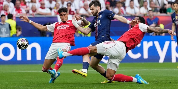 PERFOMA MENYALA: Khvicha Kvaratskhelia (tengah) dikawal Piero Hincapie dan Gabriel Magalhaes dalam laga final Liga Champions antara PSG vs Arsenal di Puskas Arena, Budapest pada Sabtu (30/5/2026). (Foto: (c) AP Photo/Petr Josek)