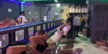 TIDAK BERKUTIK: Sejumlah pria dewasa mengangkat tangan saat tertangkap petugas sedang bermain judi di salah satu perjudia berkedok arena bermain anak. (Foto: detik.com/istimewa)