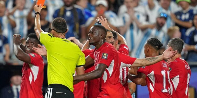POLEMIK VAR: Wasit Joao Pinheiro dari Portugal memberikan kartu merah kepada pemain Swiss Breel Embolo (kiri) dalam laga perempat final Piala Dunia 2026 antara Argentina vs Swiss di Kansas City, Missouri pada Sabtu (11/7/2026). (Foto: (c) AP Photo/Ed Zurga)