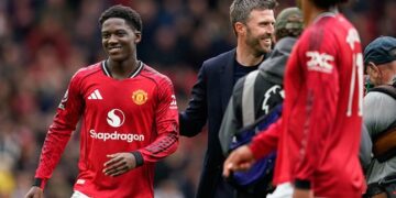 PERKUAT TIM: Gelandang Manchester United, Kobbie Mainoo, dan pelatih Michael Carrick usai laga melawan Liverpool di Old Trafford pada 3 Mei 2026. (Foto: (c) AP Photo/Dave Thompson)