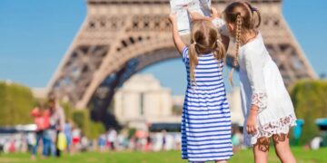LINDUNGI ANAK: Dua anak sedang bermain dengan latar belakang Menara Eiffel di Paris. Pemerintah Prancis akan melarang anak di bawah usia 15 tahun menggunakan medsos. (Foto Ilustrasi: Dok./civitatis.com)