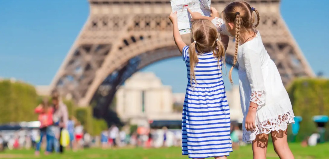 LINDUNGI ANAK: Dua anak sedang bermain dengan latar belakang Menara Eiffel di Paris. Pemerintah Prancis akan melarang anak di bawah usia 15 tahun menggunakan medsos. (Foto Ilustrasi: Dok./civitatis.com)