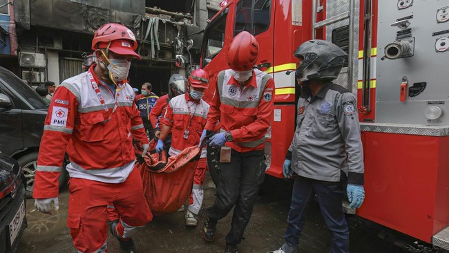 Kepala Regu Sudin Gulkarmat Jaktim Gugur Dalam Tugas 1 PROSES EVAKUASI: Petugas Sudin Gulkarmat Jakarta Timur mengevakuasi jenazah korban saat memadamkan api di Kelurahan Dukuh, Kramat Jati, Jakarta Timur pada Minggu (2/8/2026). (AFP/SYNATRIA RESPATI via CNNI)