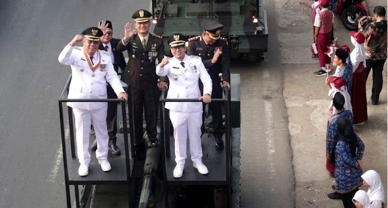 PARADE ALUTSISTA: Wali Kota Tangerang Selatan Benyamin Davnie (kiri) dan Wakil Wali Kota Pilar Saga Ichsan memimpin langsung iring-iringan kendaraan tempur yang bergerak dari Kantor Kelurahan Pondok Jagung menuju Lapangan Batalyon Kavaleri 9, Serpong Utara pada Senin (17/8/2026). (FOTO: HARIS SUNANDAR/KORANINDOPOS.COM)