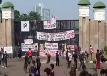 SPANDUK TUNTUTAN: Sejumlah massa unjuk rasa memasang spanduk tuntutan mereka di pagar Gedung DPR/MPR RI, Senayan, Tanah Abang, Jakarta Pusat pada Kamis (27/8/2026). (FOTO; HARIS SUNANDAR/KORANINDOPOS.COM)