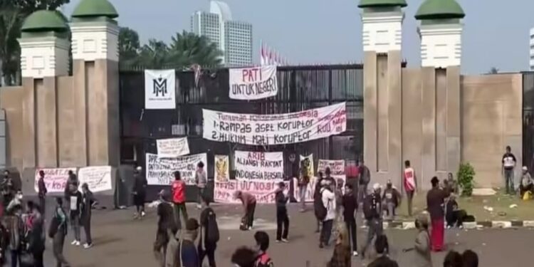 SPANDUK TUNTUTAN: Sejumlah massa unjuk rasa memasang spanduk tuntutan mereka di pagar Gedung DPR/MPR RI, Senayan, Tanah Abang, Jakarta Pusat pada Kamis (27/8/2026). (FOTO ILUSTRASI; HARIS SUNANDAR/KORANINDOPOS.COM)
