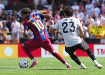 TAK SEIMBANG: Pemain Barcelona, Lamine Yamal, mengambil bola dari pemain Valencia, Filip Ugrinic, dalam pertandingan La Liga kontra Valencia pada Minggu (6/9/2026). (Foto: (c) AP Photo/Alberto Saiz)