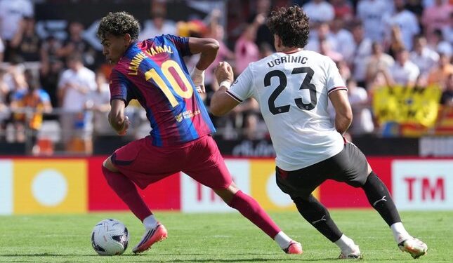 Barcelona Permalukan Valencia di Kandang Dengan Skor 5-0 tanpa Balas 1 TAK SEIMBANG: Pemain Barcelona, Lamine Yamal, mengambil bola dari pemain Valencia, Filip Ugrinic, dalam pertandingan La Liga kontra Valencia pada Minggu (6/9/2026). (Foto: (c) AP Photo/Alberto Saiz)