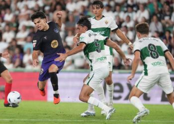 DUEL SENGIT: Pemain Barcelona Xavi Espart berebut bola dengan pemain Elche Federico Redondo dalam laga La Liga Spanyol antara Elche vs Barcelona di Elche, Spanyol pada Minggu (23/8/2026). (Foto: (c) AP Photo/Alberto Saiz)
