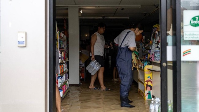 Hujan dan Banjir Bandang Landa Bangkok, Warga Panic Buying 1 BORONG SEMBAKO: Warga memborong bahan makanan di mini market pasca bencana banjir terus meluas di Bangkok. (AFP/Wikus De Wet)