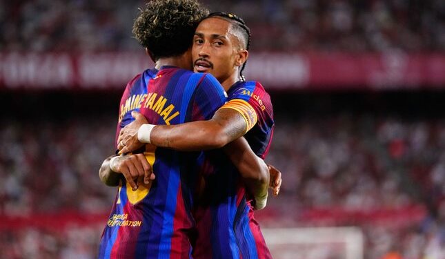 Raphinha Menepi Sejenak Dari Penggawa El Blaugrana 1 PEMAIN PRODUTIF: Raphinha memeluk Lamine Yamal usai mencetak gol ke gawang Sevilla pada Minggu (20/9/2026). (Foto: (c) AP Photo/Jose Breton)
