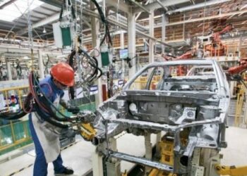 PELINDUNGAN PEKERJA: Tenaga kerja melakukan perakitan kendaraan roda empat. (Foto Ilustrasi: Bloomberg/Kevin Lee)