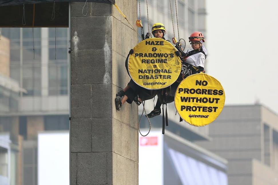Penahanan Tanpa Dasar Hukum, Polda Bebaskan Aktivis Greenpeace 2 AKSI SPEKTAKULER: Dua aktivis Greenpeace Indonesia saat memanjat Patung Selamat Datang, Bundaran HI, Jakarta Pusat pada Selasa (20/10/2026) pagi dengan cara single rope technique. (Foto: IST)